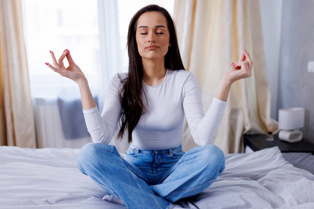 istock Young woman peacefully practicing yoga on her bed 1763773923