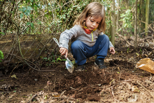 boy digging in ground to plant seed