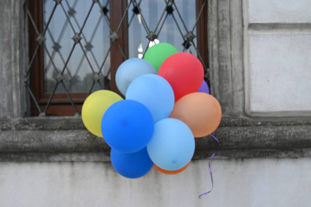 colored balloons hanging from a window for a family celebration - celebration inflatable excitement concepts imagens e fotografias de stock