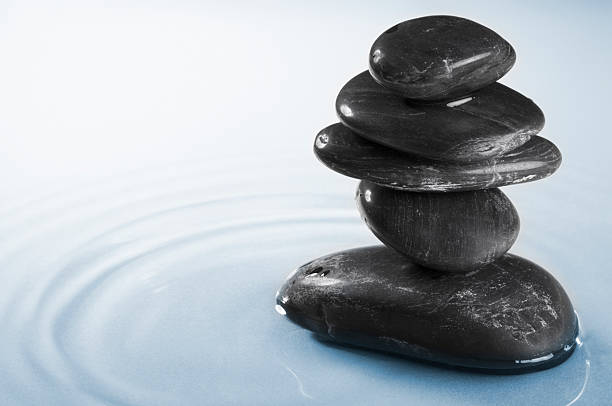 istock Five balancing smooth black pebbles in water ripples 176379052