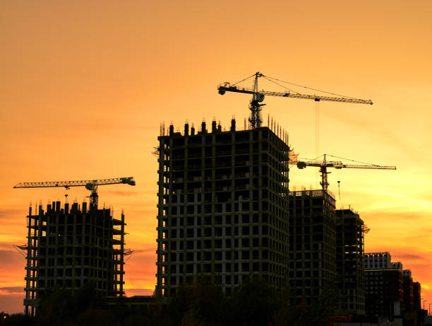 istock Tower cranes silhouette against yellow sunset 1763800086