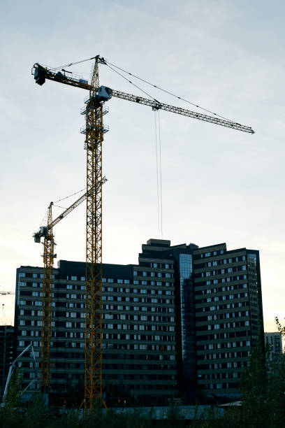 istock Tower cranes silhouette against yellow sunset 1763800623