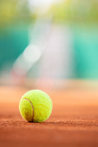 Tennis ball on clay court with copy space stock photo