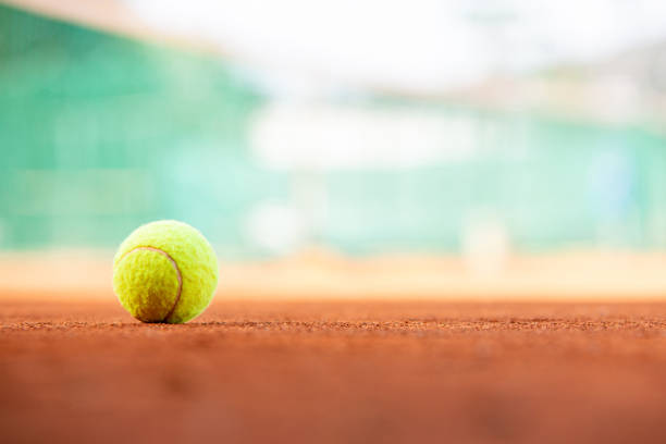 istock Tennis ball on clay court with copy space 1763841309