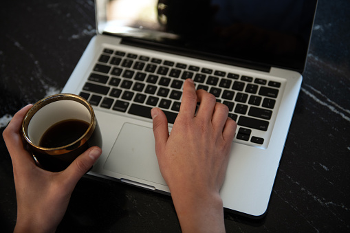 Woman working on laptop at marble table