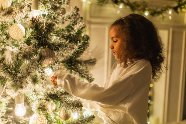 istock Little girl decorating Christmas tree 1763906144