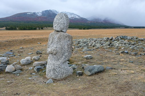 Balbal statue, marking a burial site, dating back 2,000 years in the Kazakh Bayan-Olgii Province of the Altai Mountains of Western Mongolia. The Turkic warrior human image carving, made from a single stone, stand out in remote areas of the mountains marking the graves of warrior ancestors.
