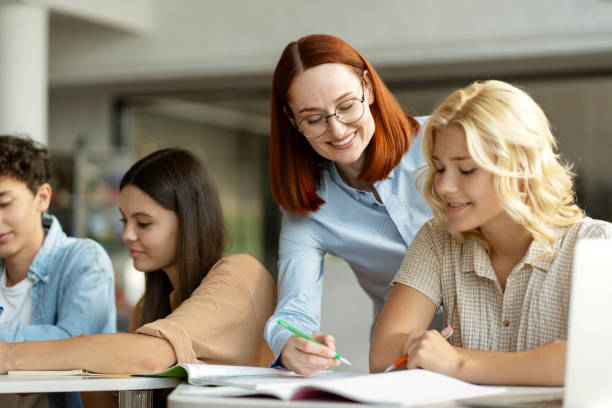 istock Teacher or tutor having lesson, learning language with school children in classroom. Education 1763926514