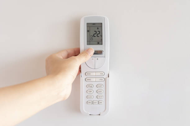 istock A woman's hand presses the power button on a home air conditioner remote 1764104430