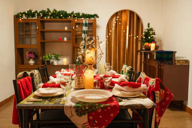 istock Empty traditional Christmas dinner table inside decorated living room with holiday garlands and dinnerware. 1764179401