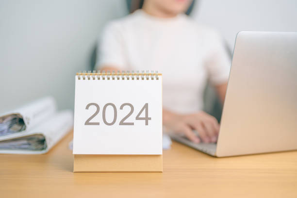 istock 2024 Year Calendar on table with business woman using laptop computer. countdown, Happy New Year, Resolution, Goals, Plan,  Action, Mission and financial Concept 1764219130