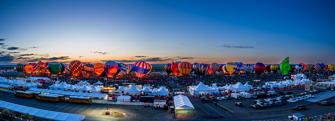 Albuquerque, New Mexico - USA - Oct 8, 2023: Panorama of hot air balloon glow after sunset at the Albuquerque International Balloon Fiesta