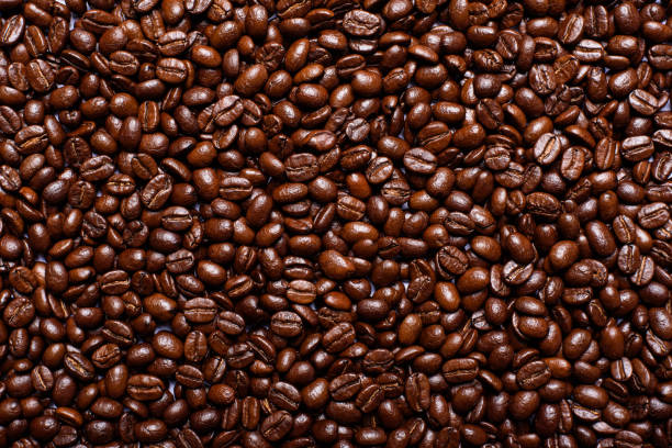 istock Dark brown roasted coffee beans background. 1764263975