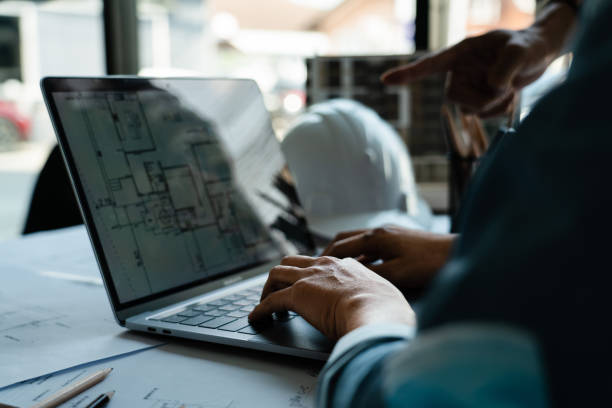 istock Two engineer working to discuss and brainstorming about construction blueprint on laptop in office 1764272542