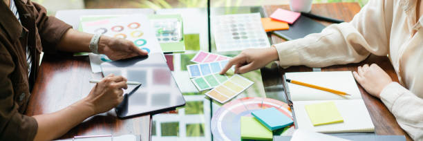 istock Two creative graphic designers pointing on colors swatch to discussing for designing new project 1764272556