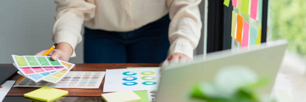 istock Creative graphic designer holding color swatch to comparing color on document for designing project 1764273599