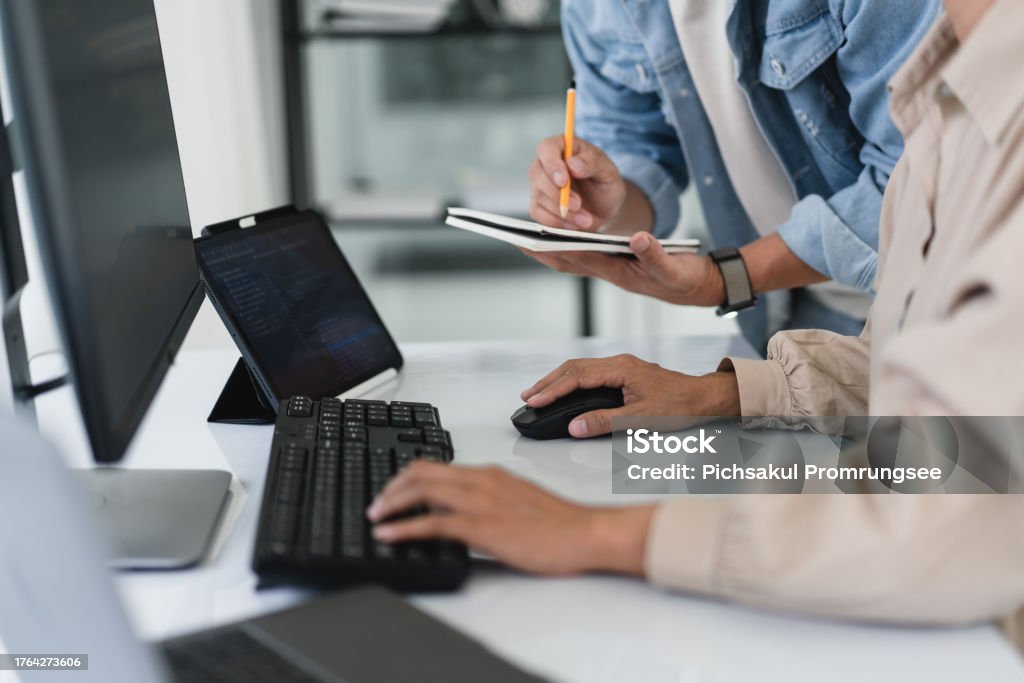 Two Developer Programmer Typing Code And Writing Data While Discussing ...