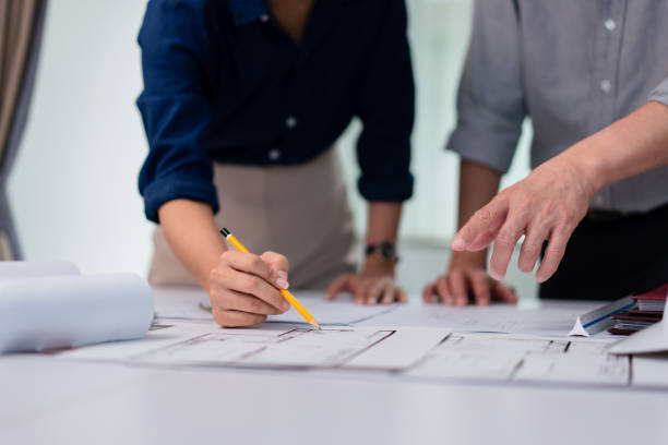 istock Two architects pointing on blueprint to discuss and planning about construction building project 1764294639