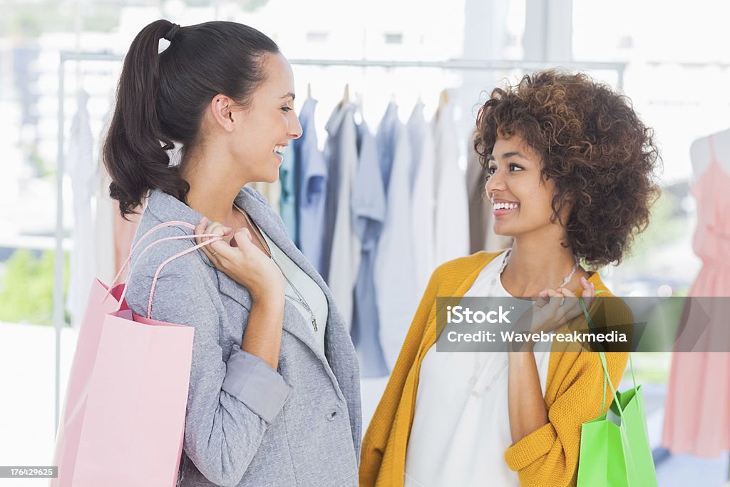 笑顔のショッピングバッグを持つ女性 - カジュ��アルウェアのロイヤリティフリーストックフォト