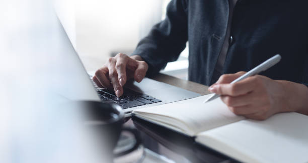 obchodní žena ruce s perem psaní na notebook plánovač a brouzdá po internetu na přenosném počítači. plánování obchodní ženy, online práce na přenosném počítači, plánování projektů - studující sociální role - stock snímky, obrázky a fotky
