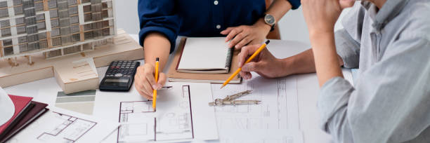 istock Two architects are discussion and analysis about construction of building project on blueprint 1764313608