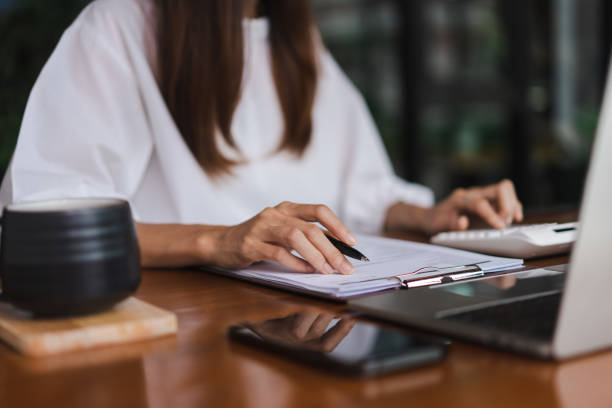istock Businesswomen using calculator to checking financial document while working in outside office 1764313636