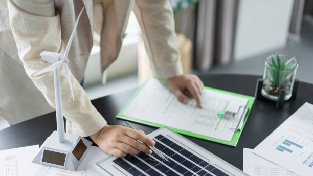 istock Alternative energy environment businesswoman working to checking solar cell panel and document 1764314179