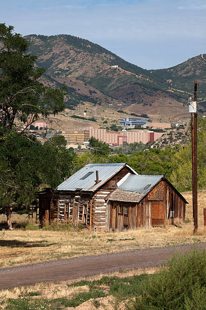 Pioneer cabin and Lockheed Martin Colorado An early Colorado pioneer cabin stands in front of Rocky Mountain home of Aerospace giant Lockheed Martin outside Denver, Colorado. littleton colorado stock pictures, royalty-free photos & images