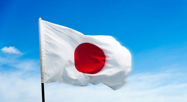 istock Japan flag waving on blue sky background 1764317893