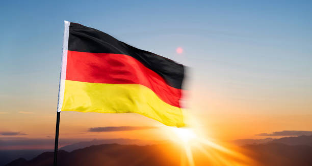 istock German flag waving against sunrise sky background 1764318326