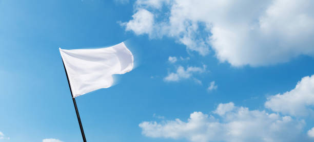 istock White flag flying against blue sky background 1764318960