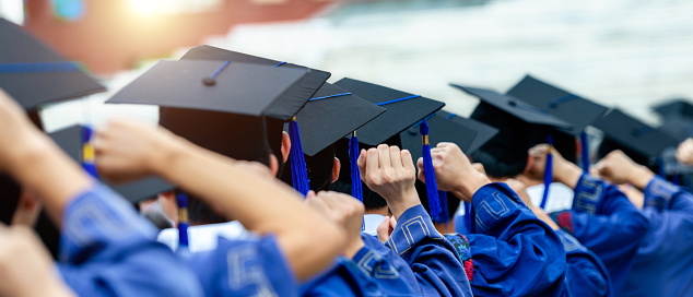 Canada - June 13, 2023: A procession of graduating university students in formal academic gowns go in to receive their diplomas