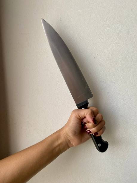 A hand holding black knife with white back