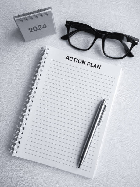 istock ACTION PLAN, text on white blank template notepad with 2024 desk calendar, pen and glasses. Blank paper for to do list note, create idea concepts. Mockup space of vertical page on spiral notebook. 1764380348