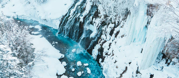 Shirahige Waterfall with Snow in winter, Biei river flow into Blue Pond. landmark and popular for attractions in Hokkaido, Japan. Travel and Vacation concept Shirahige Waterfall with Snow in winter, Biei river flow into Blue Pond. landmark and popular for attractions in Hokkaido, Japan. Travel and Vacation concept shirogane blue pond stock pictures, royalty-free photos & images