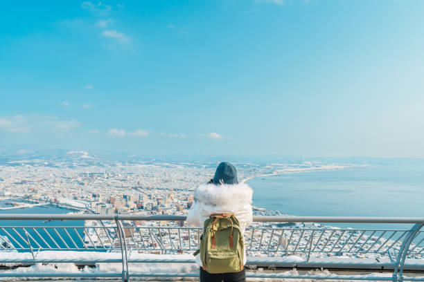 mujer turista de visita en hakodate, viajero en suéter vista turística desde la montaña hakodate con nieve en invierno. punto de referencia y popular para atracciones en hokkaido, japan.travel y concepto de vacaciones - tourism panoramas winter travel locations fotografías e imágenes de stock