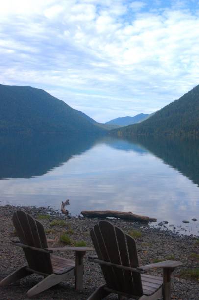 istock Two Adirondack chairs on the beach next to a calm lake 1764418150