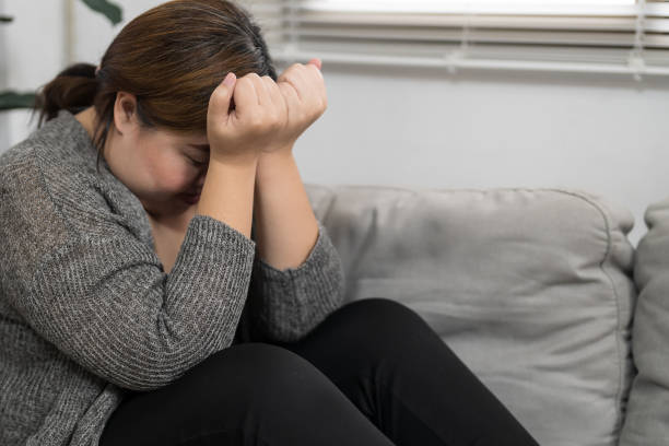 istock Sad Overweight plus size woman thinking about problems on sofa upset girl feeling lonely and sad from bad relationship or Depressed woman disorder mental health. 1764428950