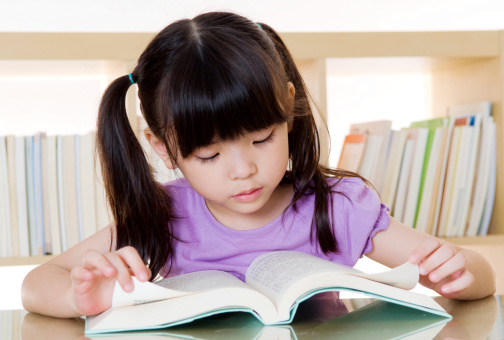 cute asian kid reading a book