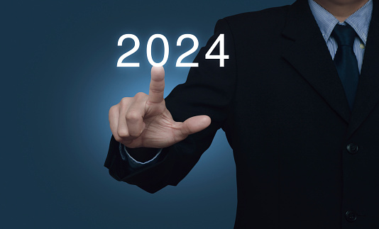 Businessman pressing 2024 letter over light blue wall, Business happy new year 2024 cover concept