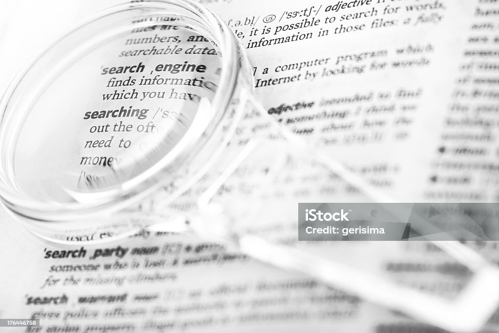 Lente di ingrandimento nella parte anteriore di un dizionario - Foto stock royalty-free di Allievo
