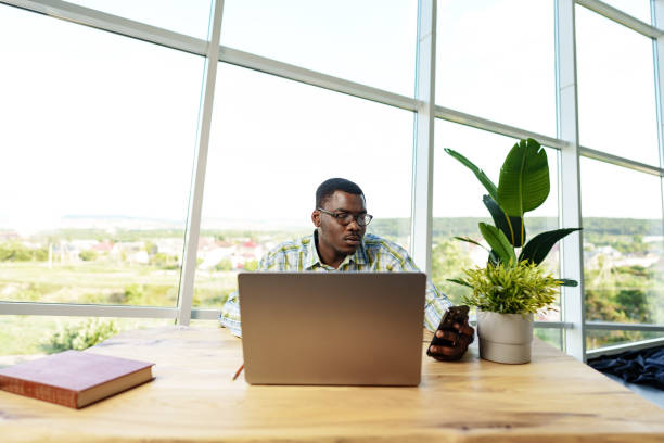 istock Young african man working on laptop in office 1764474590
