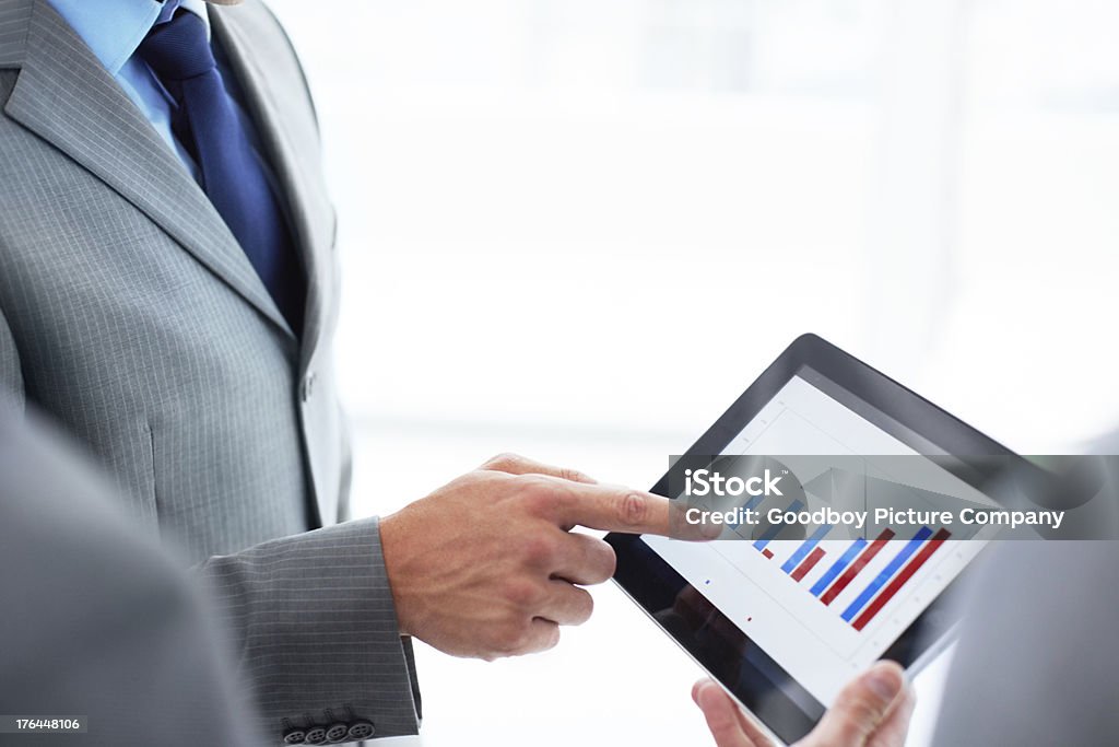 Our future is looking bright! A cropped image of three businessmen pointing to a digital tablet displaying a statistics graph 30-39 Years Stock Photo