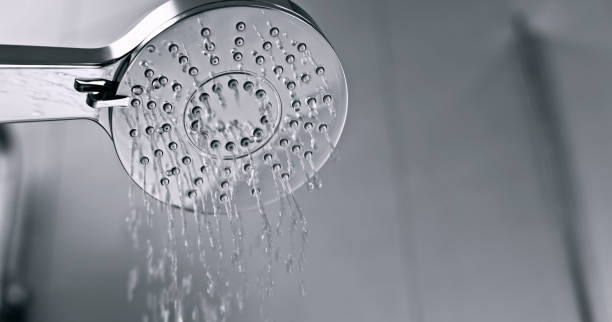 Water flowing from shower head Low angle view of water flowing from shower head in bathroom. showerhead water filter stock pictures, royalty-free photos & images