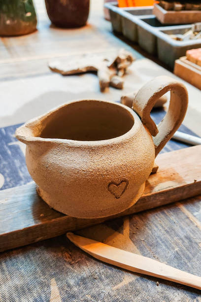 istock Handmade creamer. A small earthenware jug. A clay jug on a tray before the firing process at high temperature in the furnace at the factory. Pottery workshop. 1764517960