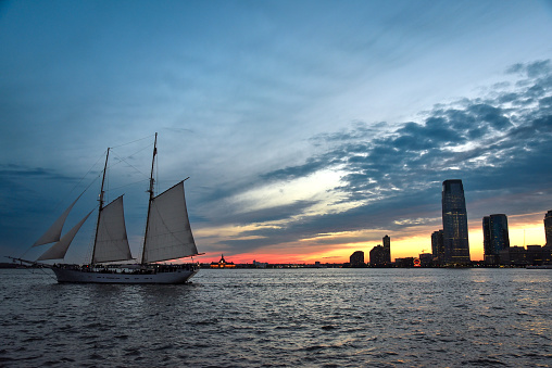 A schooner sailing at dusk on Hudson River, New York City.