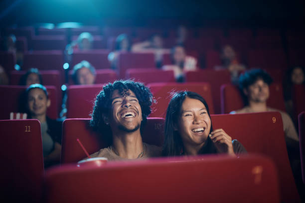 Cheerful diverse couple enjoying in a movie at cinema.