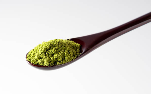 istock Matcha and wooden spoon on white background. 1764564332
