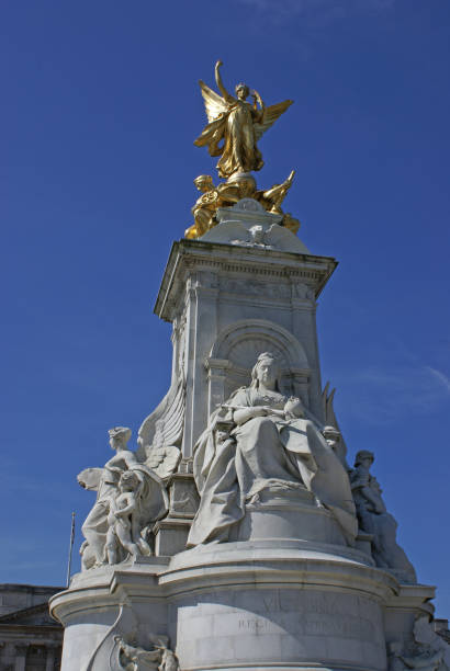 The Victoria Memorial in London stock photo. The Victoria Memorial is a bronze statue which is located outside Buckingham Palace in London, England, United Kingdom. The Victoria Memorial is a monument to Queen Victoria, located at the end of The Mall in London, and designed and executed by the sculptor Sir Thomas Brock. Designed in 1901, it was unveiled on 16 May 1911, though it was not completed until 1924. It was the centrepiece of an ambitious urban planning scheme, which included the creation of the Queen’s Gardens to a design by Sir Aston Webb, and the refacing of Buckingham Palace (which stands behind the Victoria Memorial) by the same architect. Photography Credit: Ogulcan Aksoy, SCA Studio Can Aksoy Limited, London, England.