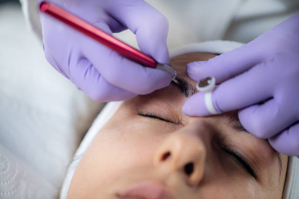 istock Beautician microblading eyebrows. Professional eyebrow microblading at beauty salon. 1764577334